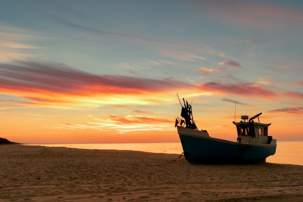 Boat to Bar: The Journey of Fresh Seafood at Gallier’s 1 Fishing boat resting on a beach at sunrise