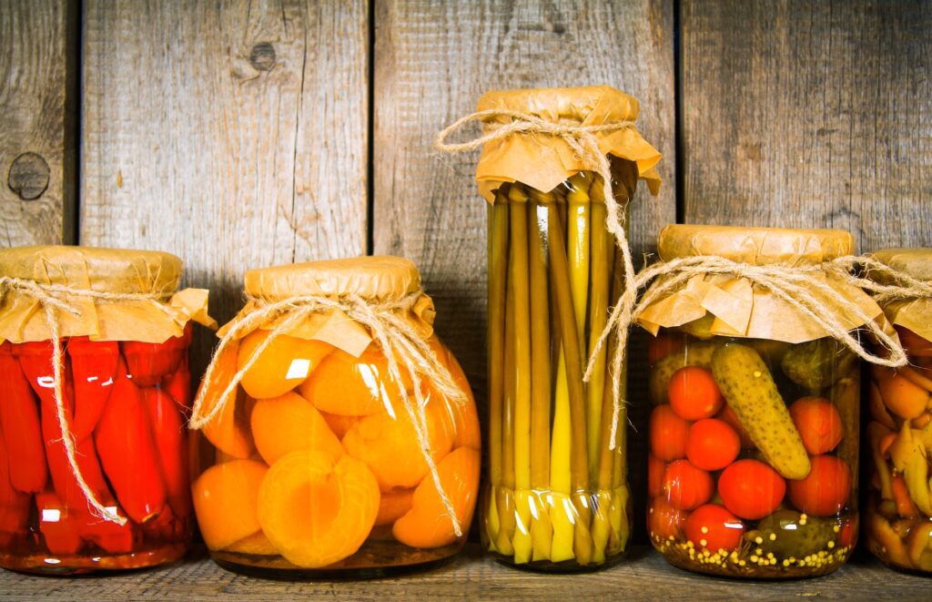 Top Southern Cooking Techniques You Can Try at Home 4 Homemade pickled vegetables and preserves in rustic glass jars on a wooden shelf