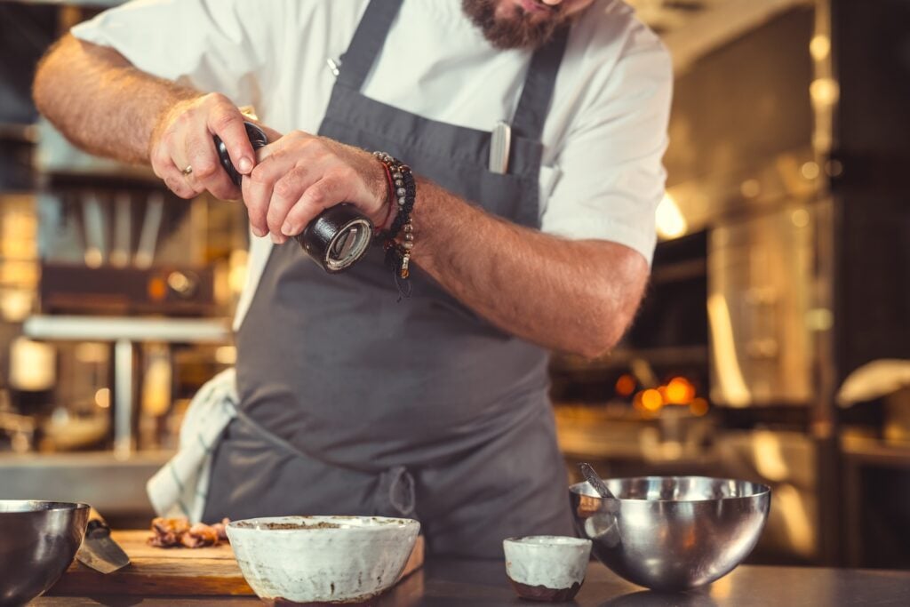The Role of Roux and Stock in Southern Dishes 2 Professional chef seasoning stock in a restaurant kitchen, capturing the essence of Southern culinary tradition.