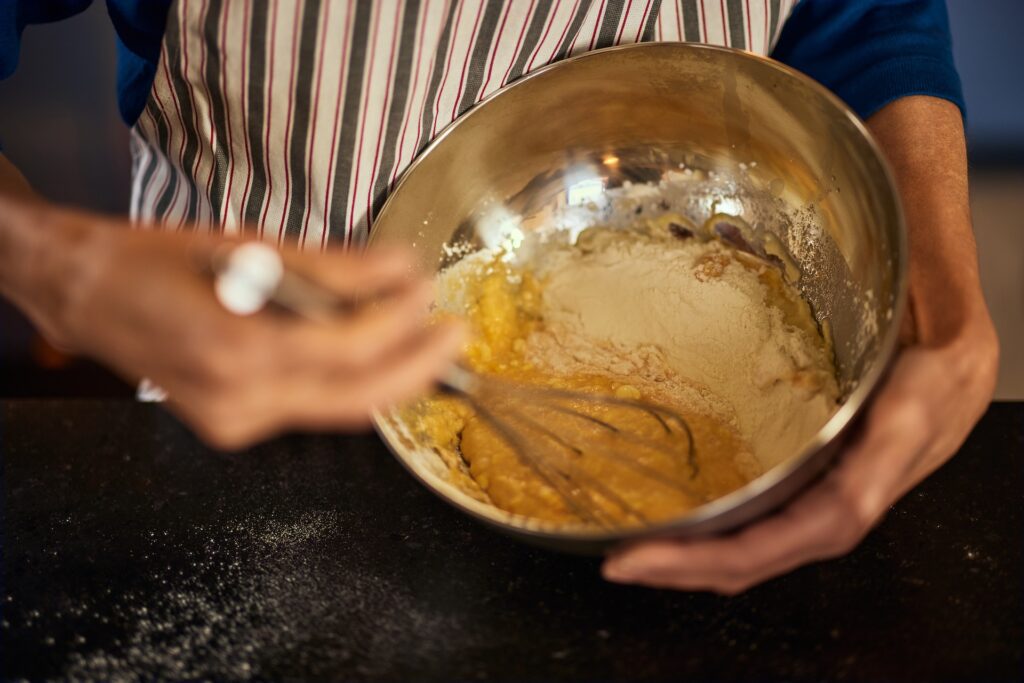 The Role of Roux and Stock in Southern Dishes 1 Close-up of a chef whisking flour and fat in a bowl while making traditional Louisiana-style roux.