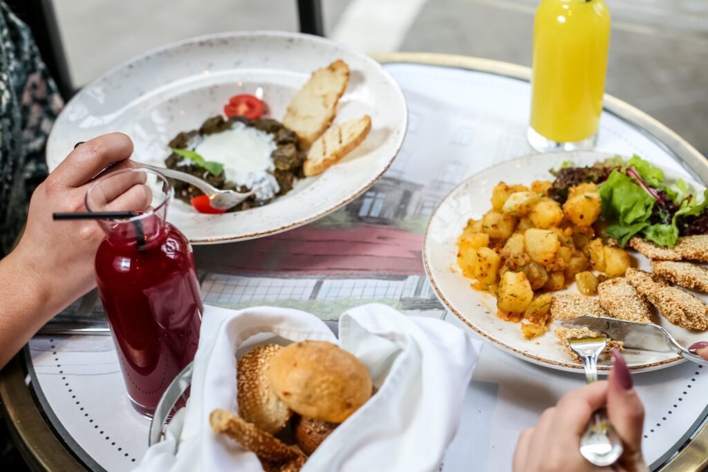 Friends enjoying a casual brunch at a local restaurant with daylight and colorful plates.