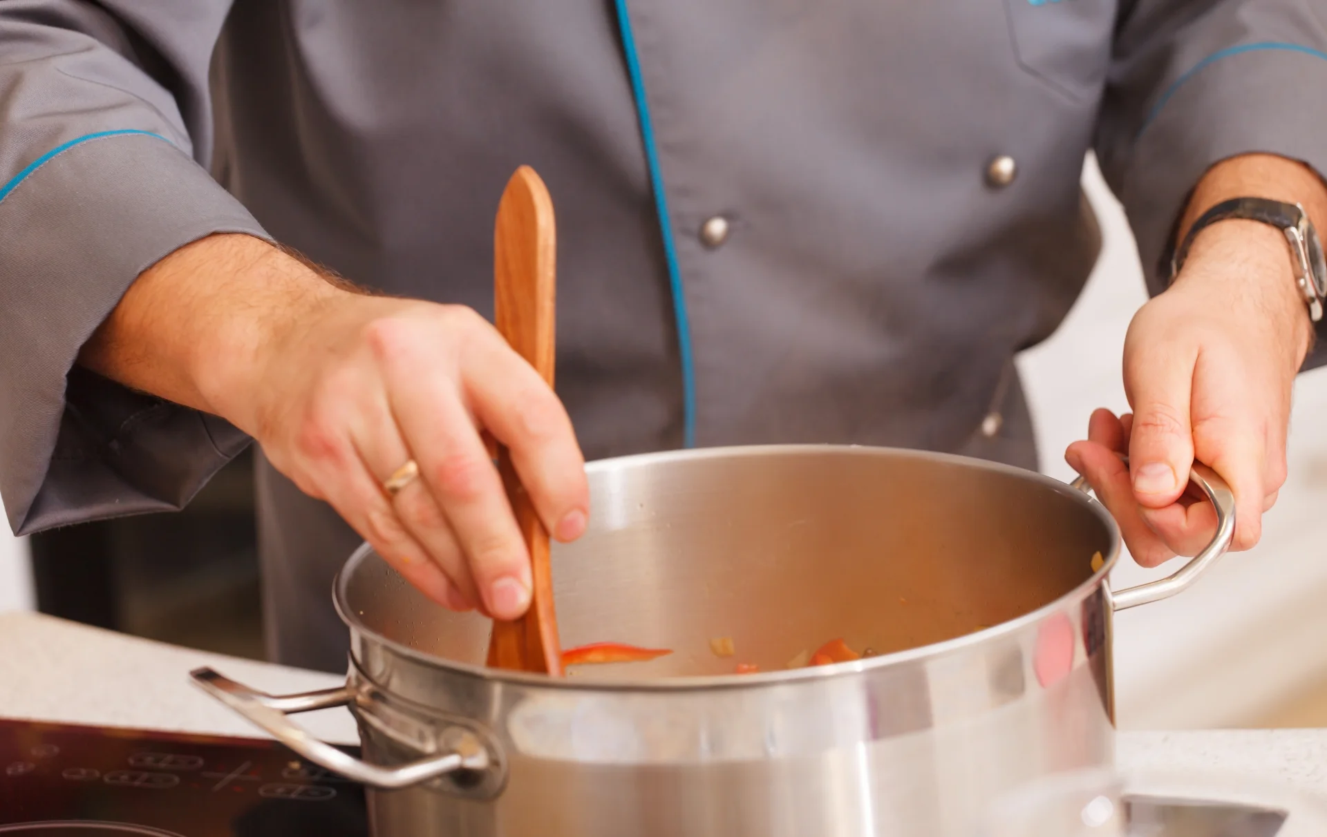 Chef stirring ingredients in a pot on the stove