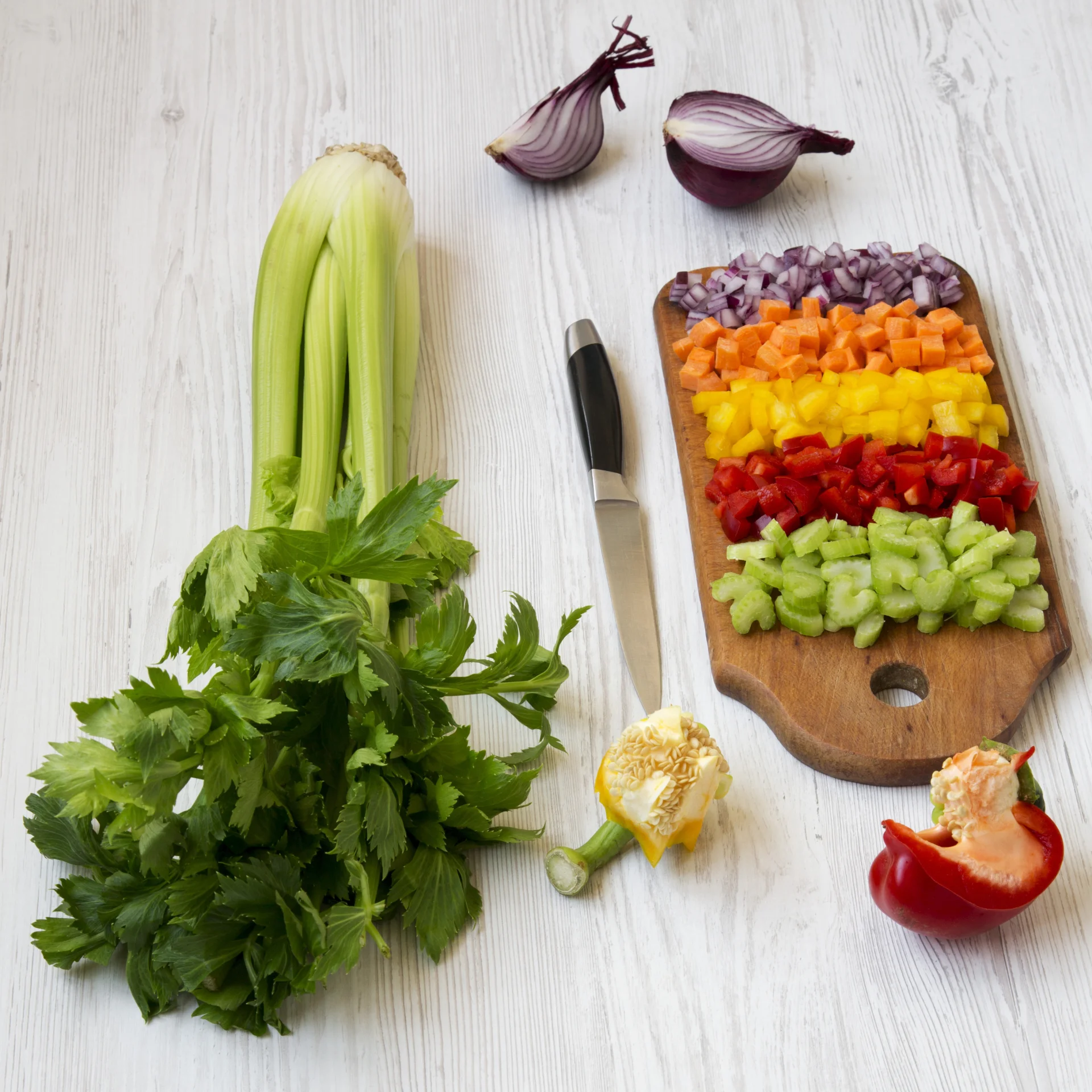 Chopped vegetables including celery, onion, bell peppers on a cutting board