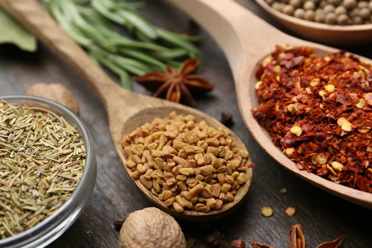 Aromatic Cajun and Creole spices and herbs in wooden spoons on rustic table