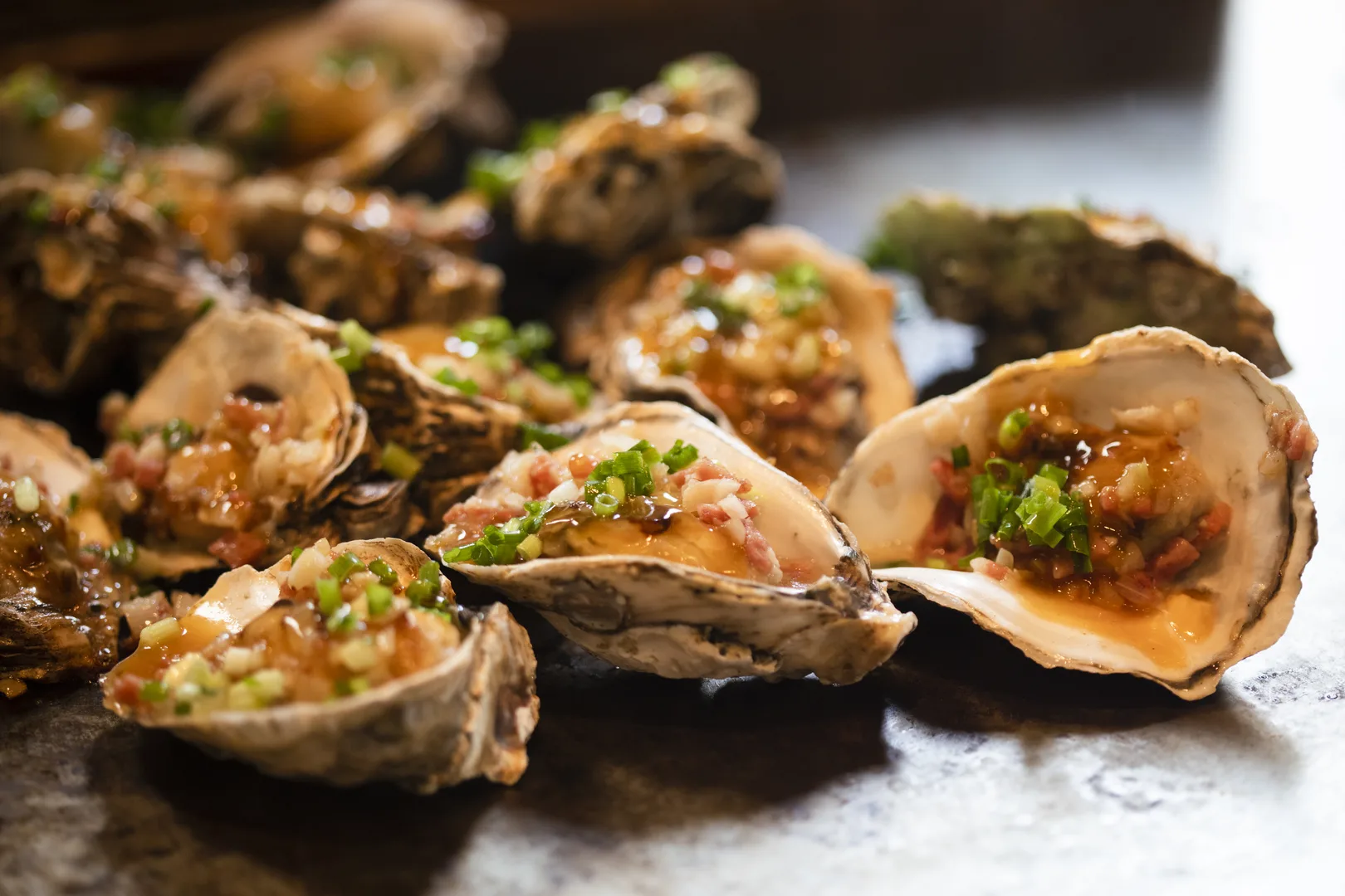 Grilled oysters with garlic butter and chili on a barbecue grill