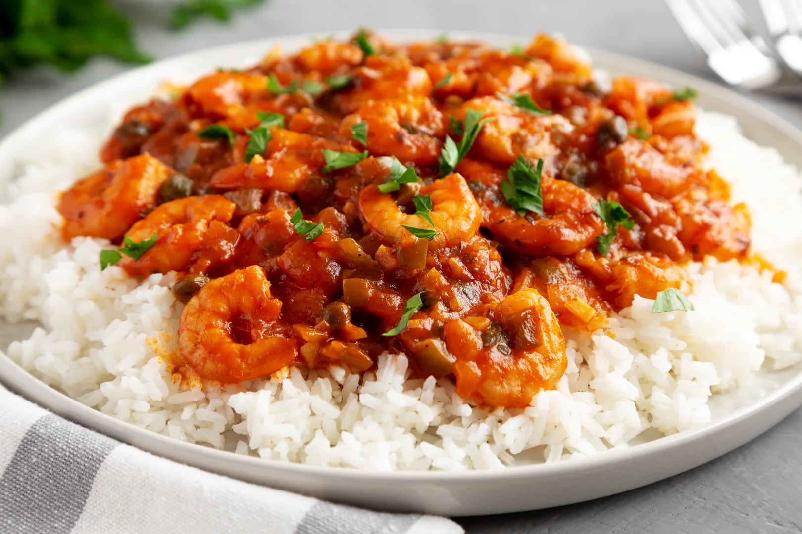 Shrimp Creole served over fluffy white rice with tomato sauce and fresh parsley