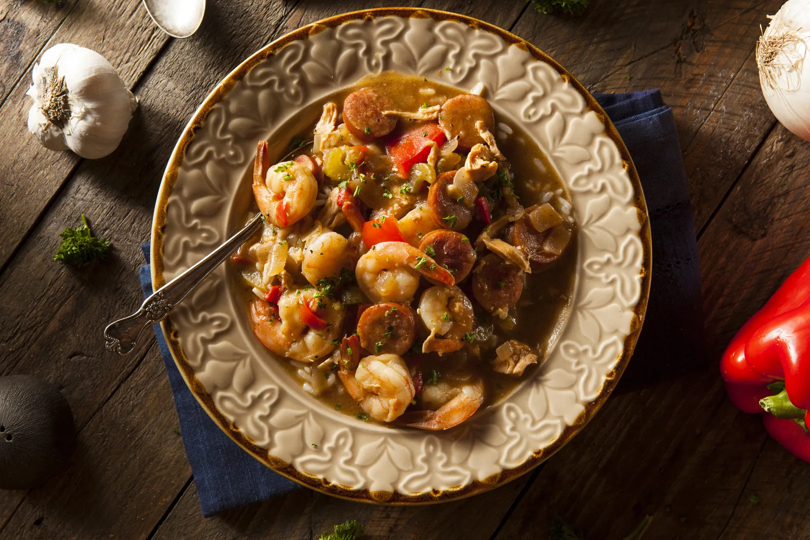 Cajun shrimp and sausage gumbo served in a rustic bowl on wooden table