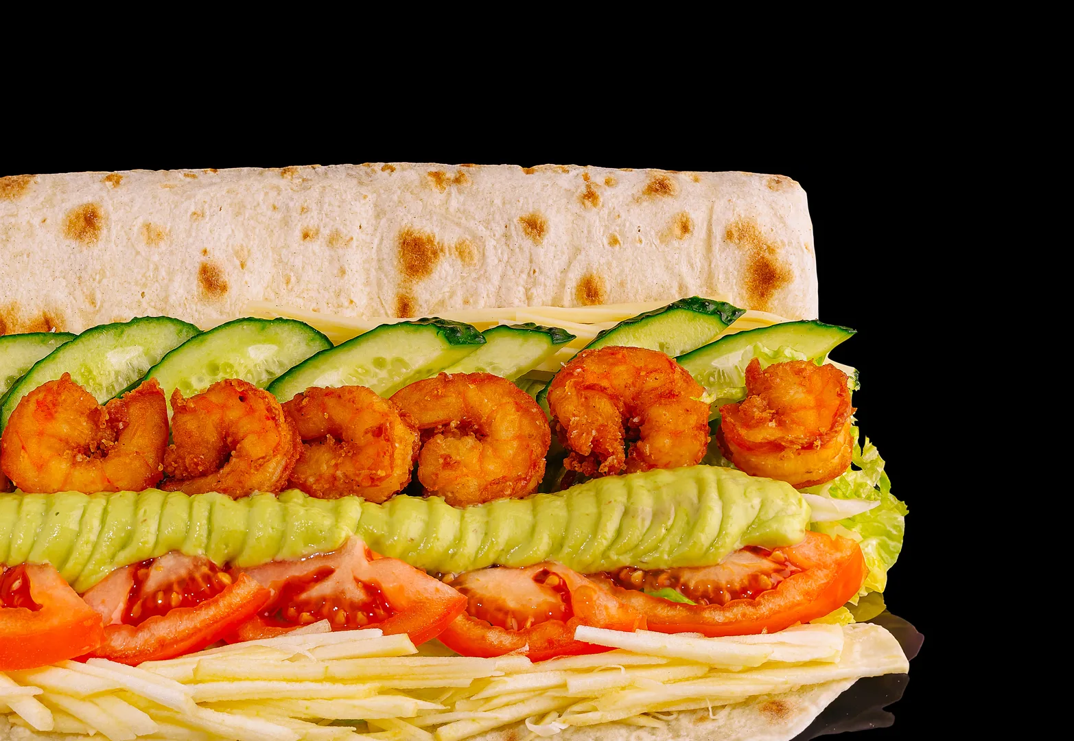 Loaded shrimp sandwich with fresh vegetables on dark background